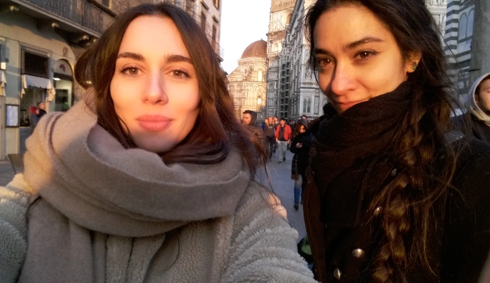 Daniela and Paola stand together on a city street.