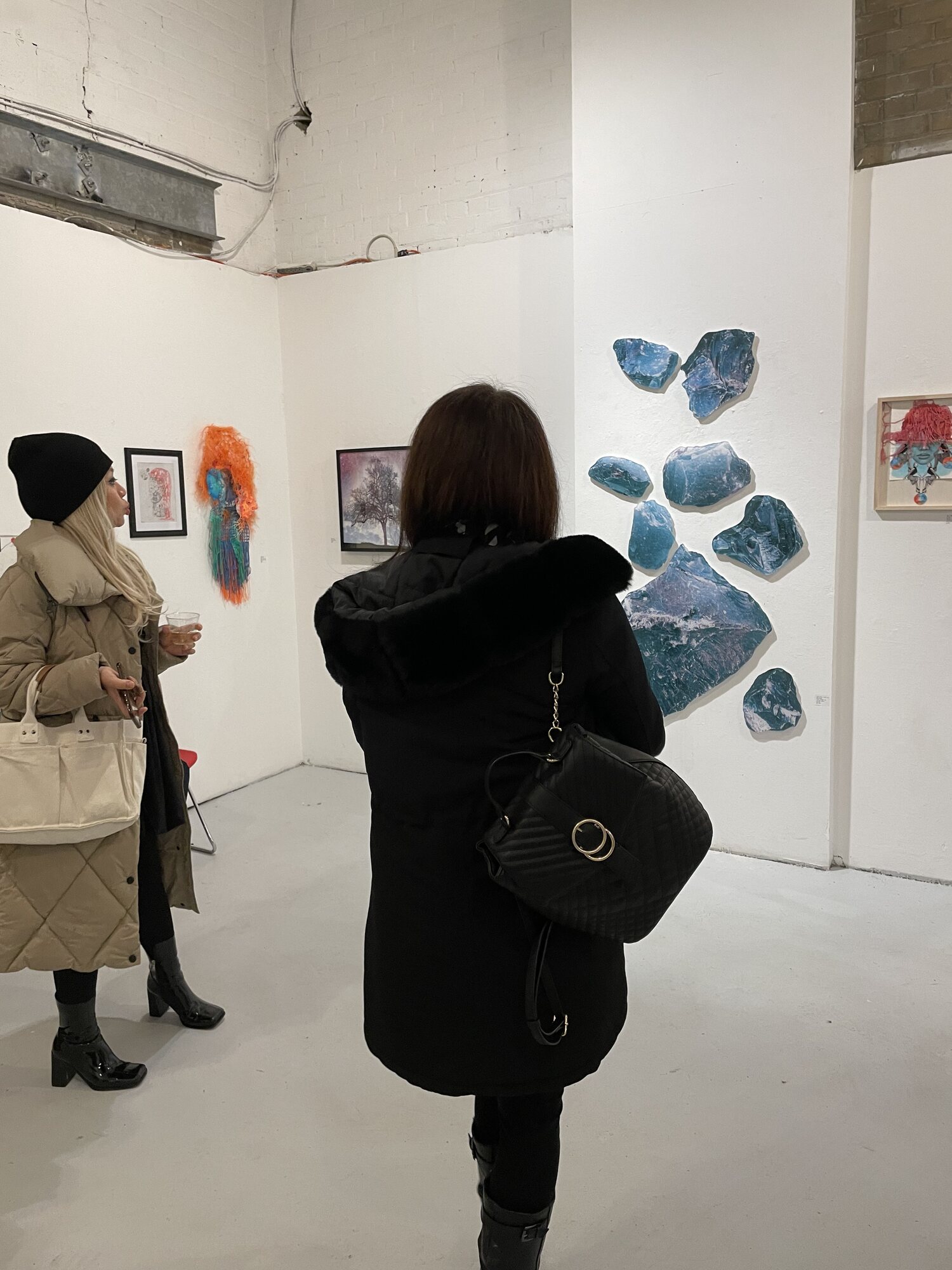 A wall of Kezleigh's blue acrylic pieces at an opening