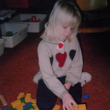 Kezleigh as a child playing with blocks in kindergarten